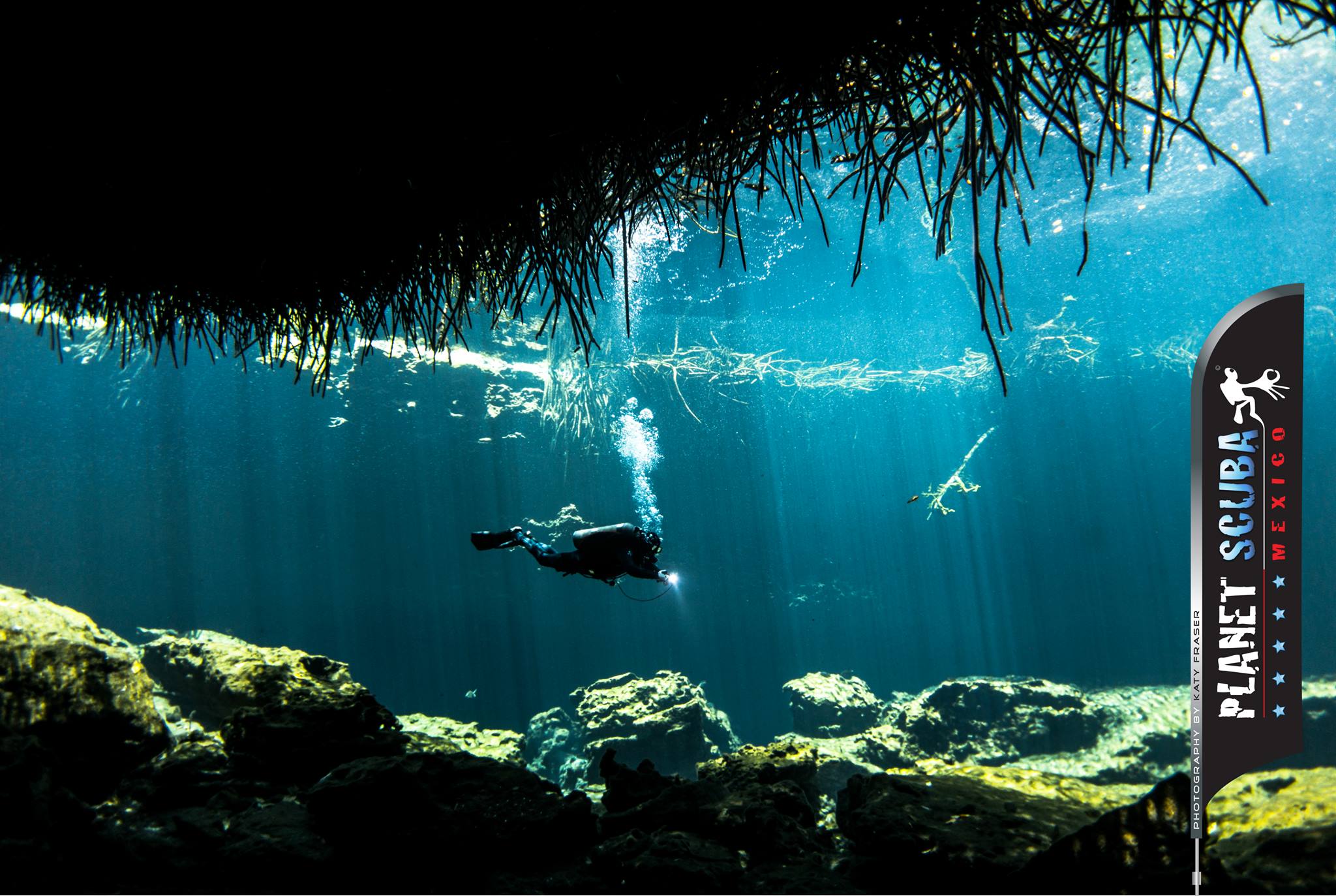 Cavern dive — diver silhouetted in light shafts